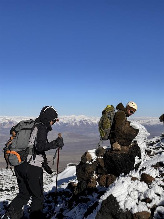 Cordada junto al mojón de la cumbre del Tromen