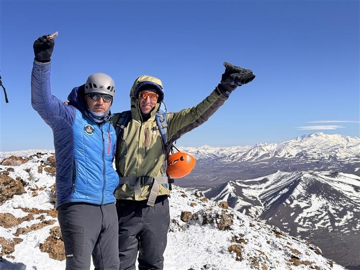 Guía de Rumbo Norte celebrando en la cumbre junto a un participante